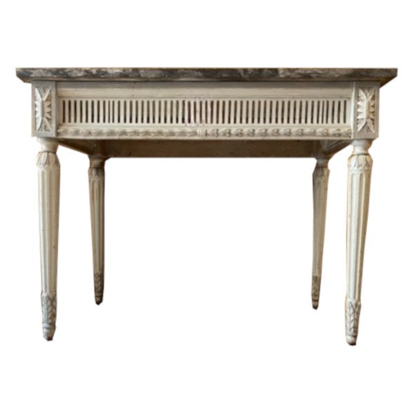 Console d'époque Louis XVI, reposant sur quatre pieds aux traverses ajourées.